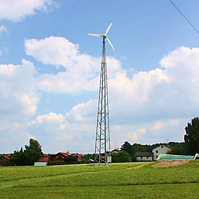 Kleinwindenergieanlage mit Gittermast im ländlichen Raum.